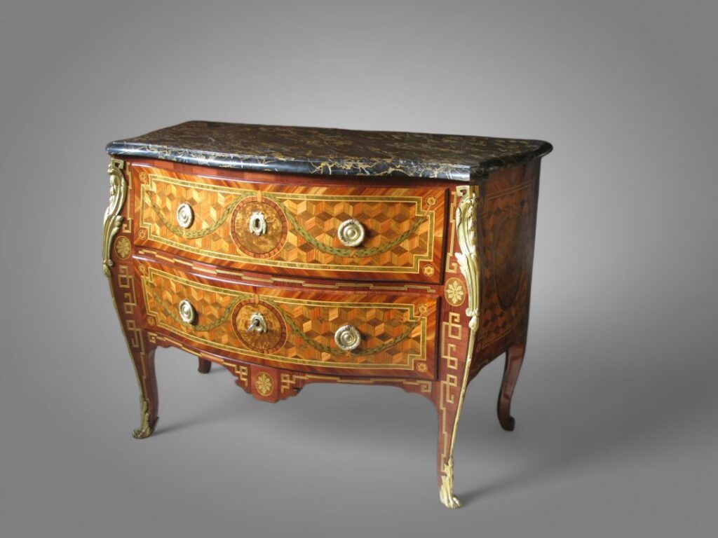 Commode galbée de style Louis XVI en marqueterie géométrique, illustrant un meuble à secrets sur-mesure avec vernis au tampon et ornements de bronze finement ciselés